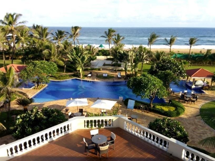 Sea view over the pool, gardens and Bay of Bengal beach at The Hans Coco Palms, Puri
